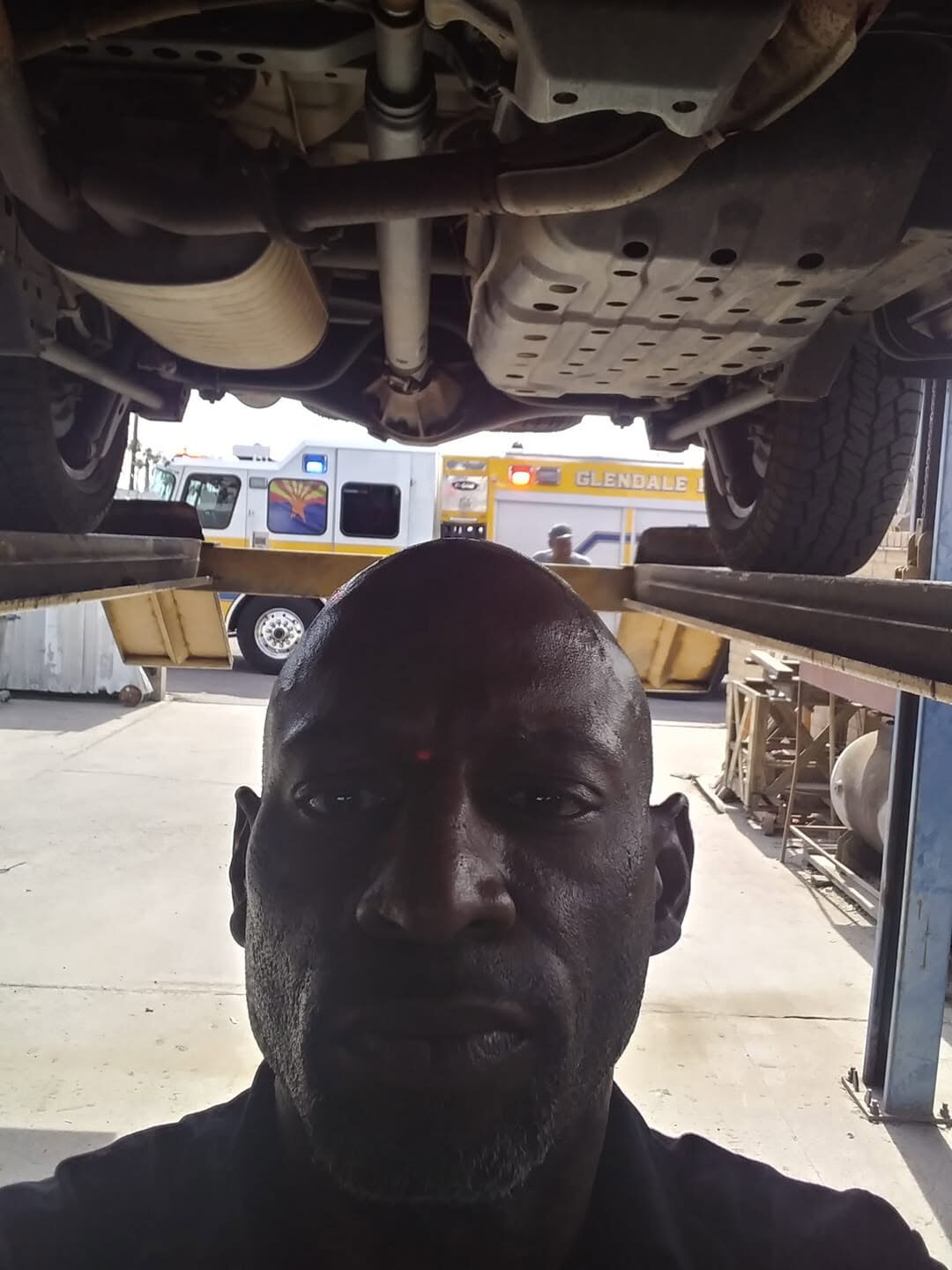 Ryan working under a vehicle on a lift in the Valley