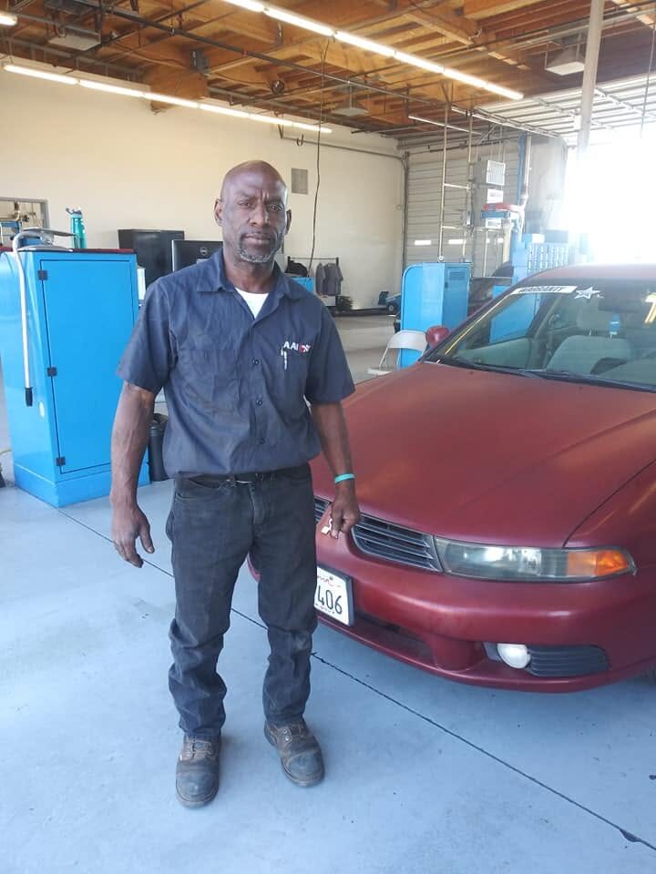 Ryan, founder of BaldHead Automotive, standing next to a vehicle in his shop in Phoenix, Arizona